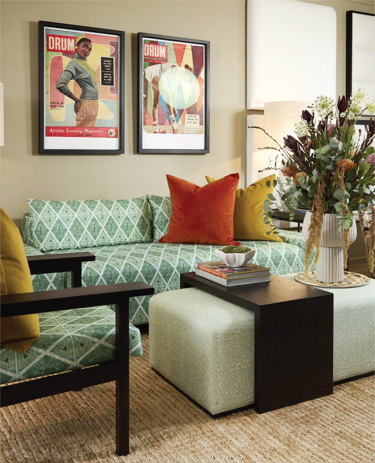 Living room with a green patterned sofa, colorful pillows, and decorative items.