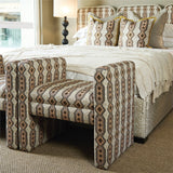 Patterned chair in front of a bed with matching bedding in a bedroom setting