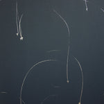 Detail of a wallpaper in an elongated paint splatter pattern in metallic silver on a navy field.
