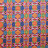 Close up of printed fabric with collaged pattern with striped and solid diamonds, squares and ovals in orange, red, pink, blue and green. 