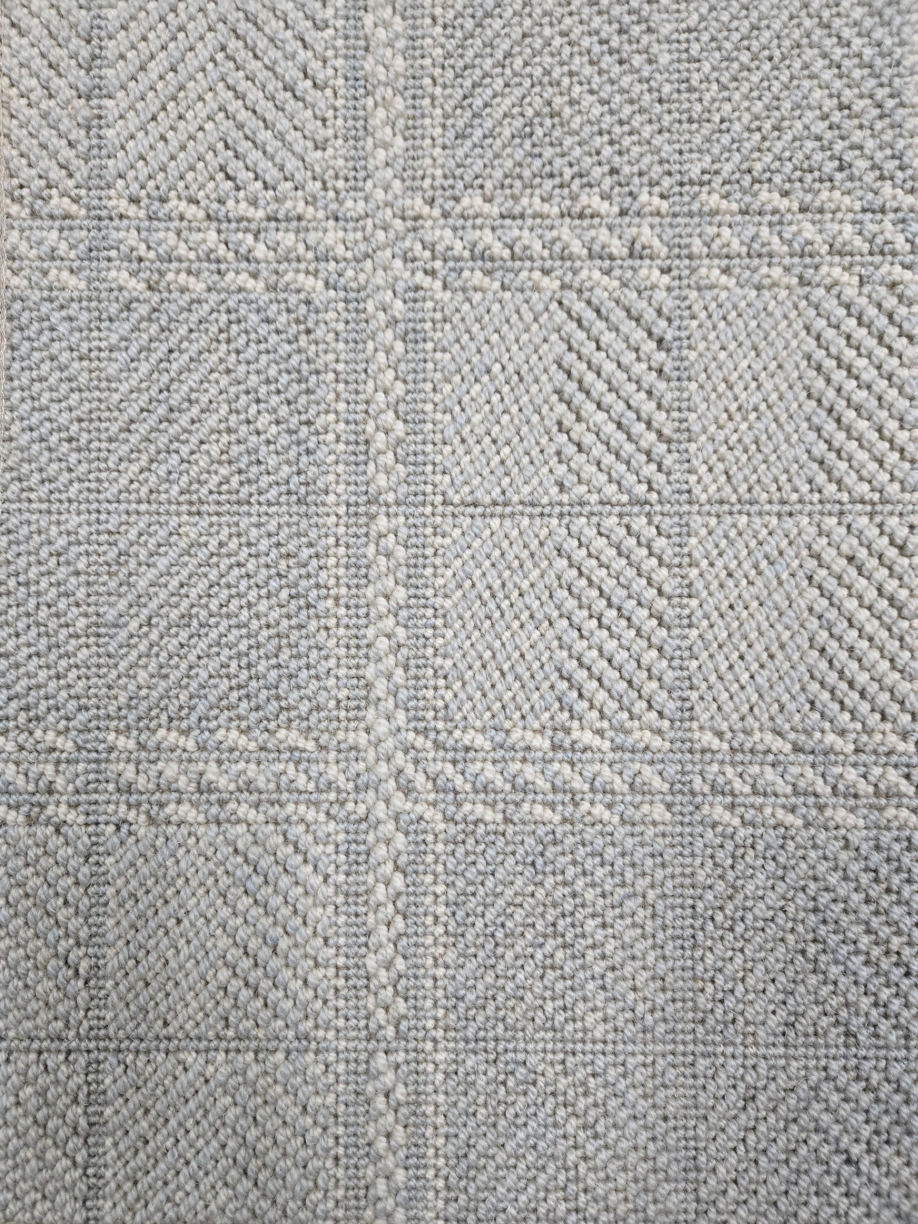 Broadloom carpet in wide box checkerboard pattern in light blue and cream. 
