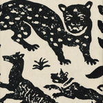 Detail of wallpaper in a playful animal print in black on a cream field.