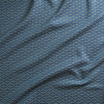 Close up of gently draped woven Indoor-Outdoor fabric with small scale geometric ditsy print in green and ivory on navy blue. 