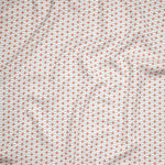Close up of gently draped woven Indoor-Outdoor fabric with small scale geometric ditsy print in coral and light blue on white. 