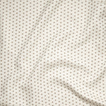 Close up of gently draped woven Indoor-Outdoor fabric with small scale geometric ditsy print in beige and taupe on ivory. 