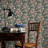 Room interior with pink and blue floral wallpaper, wooden chair, and desk lamp.