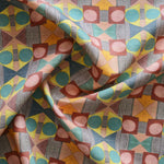 Close up of gently draped printed fabric with a complex geometric pattern with pink, red, blue, yellow, orange and turquoise