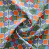 Close up of gently draped printed fabric with a complex geometric pattern with blue, orange, green, pink and red. 
