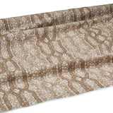 Draped fabric coming off a roll with monochomatic geometric stripe and mottled textural background in shades of  brown.