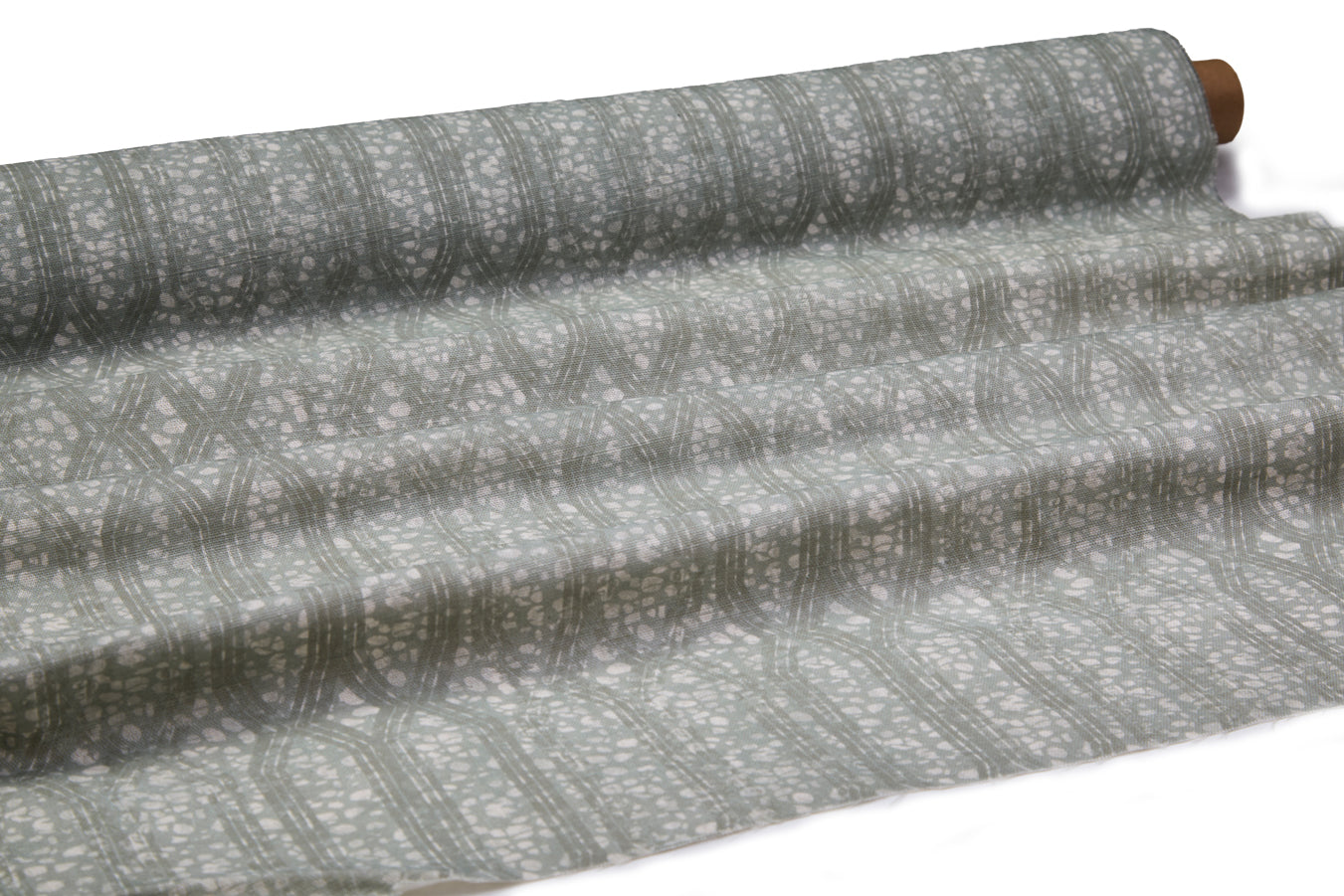 Draped fabric coming off a roll with monochomatic geometric stripe and mottled textural background in shades of grey.