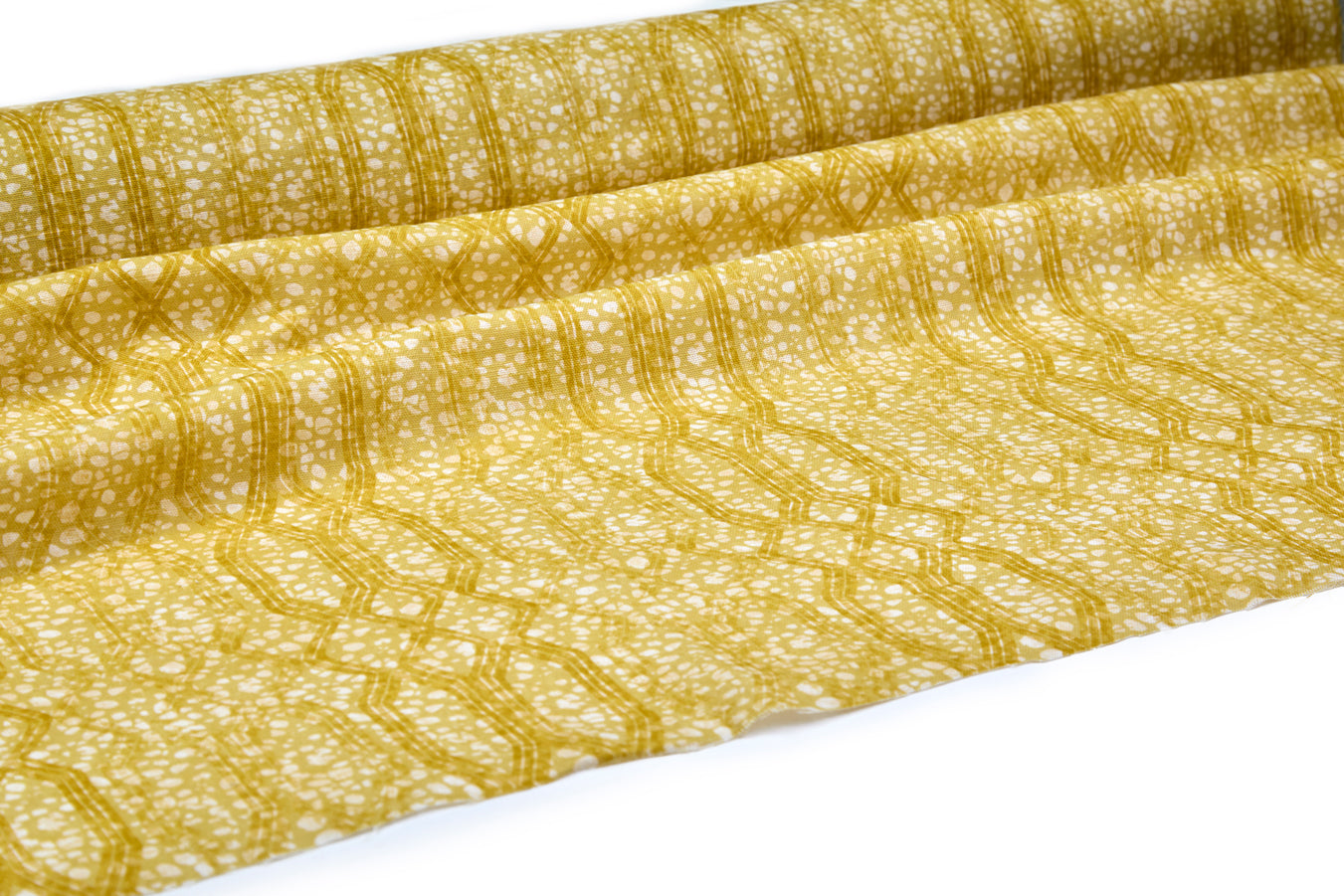 Draped fabric coming off a roll with monochomatic geometric stripe and mottled textural background in shades of yellow.