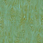 Detail of fabric in a textural wood grain print in green on a turquoise field.