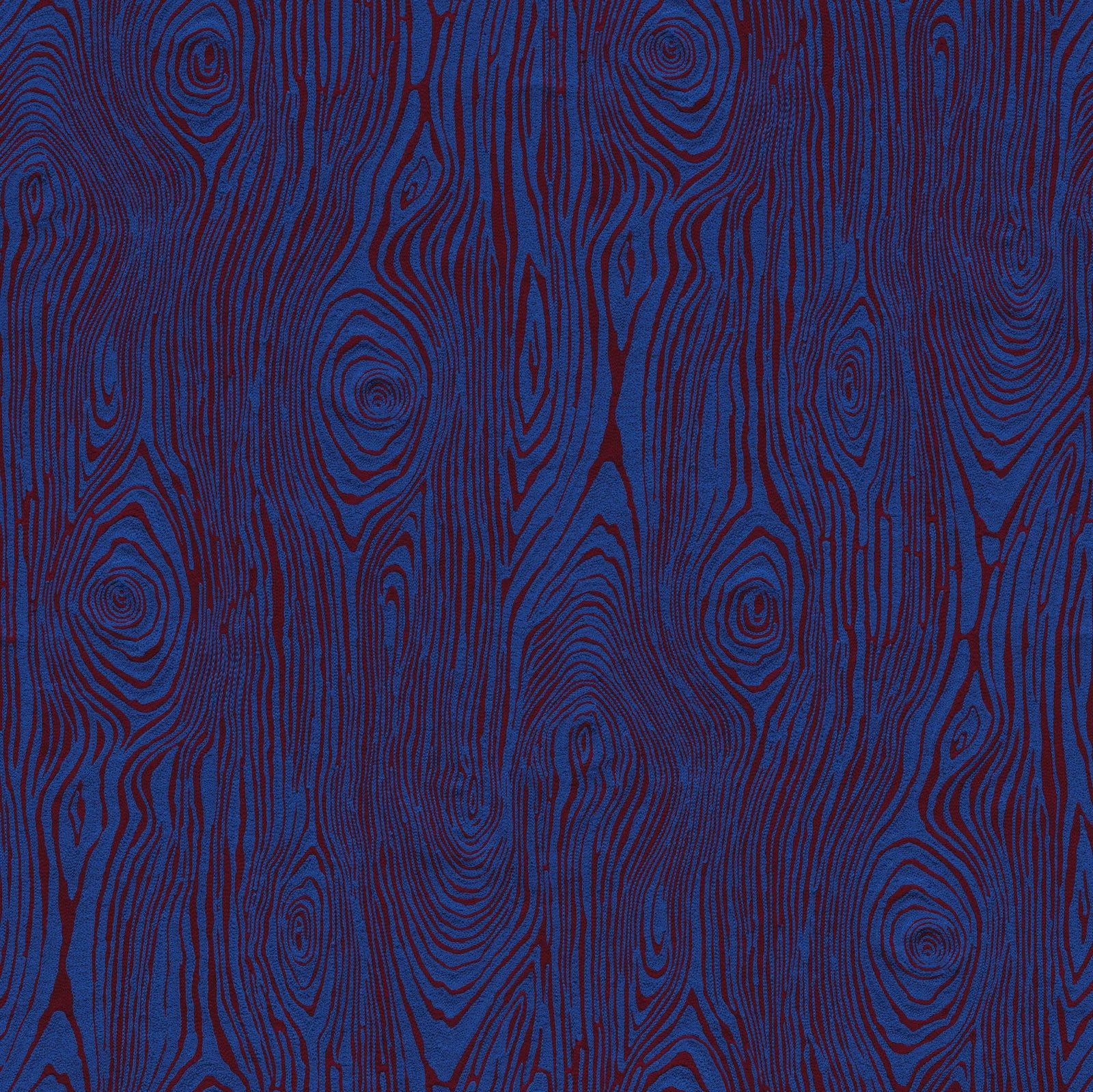 Detail of fabric in a textural wood grain print in red on a blue field.