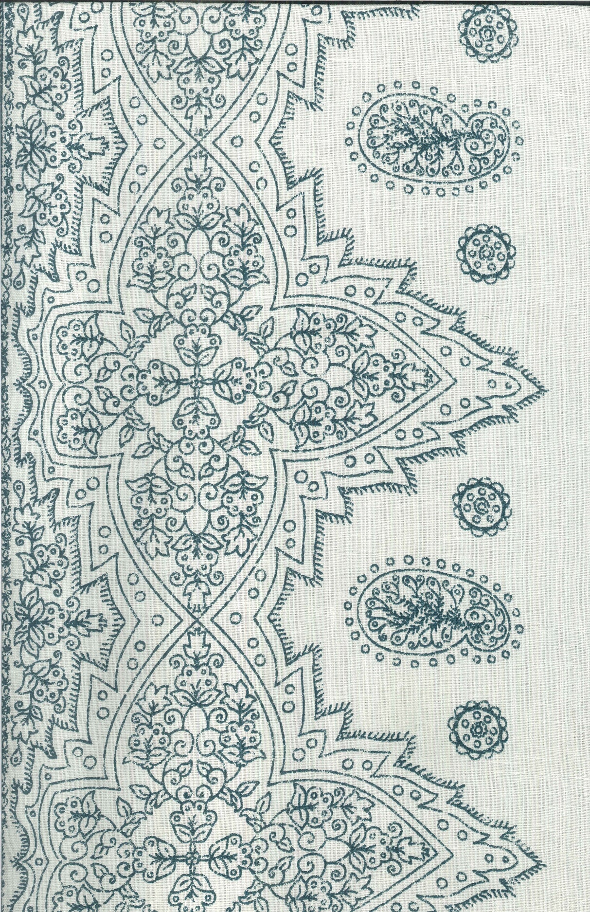 Detail of fabric in a dense paisley border print in navy on a cream field.