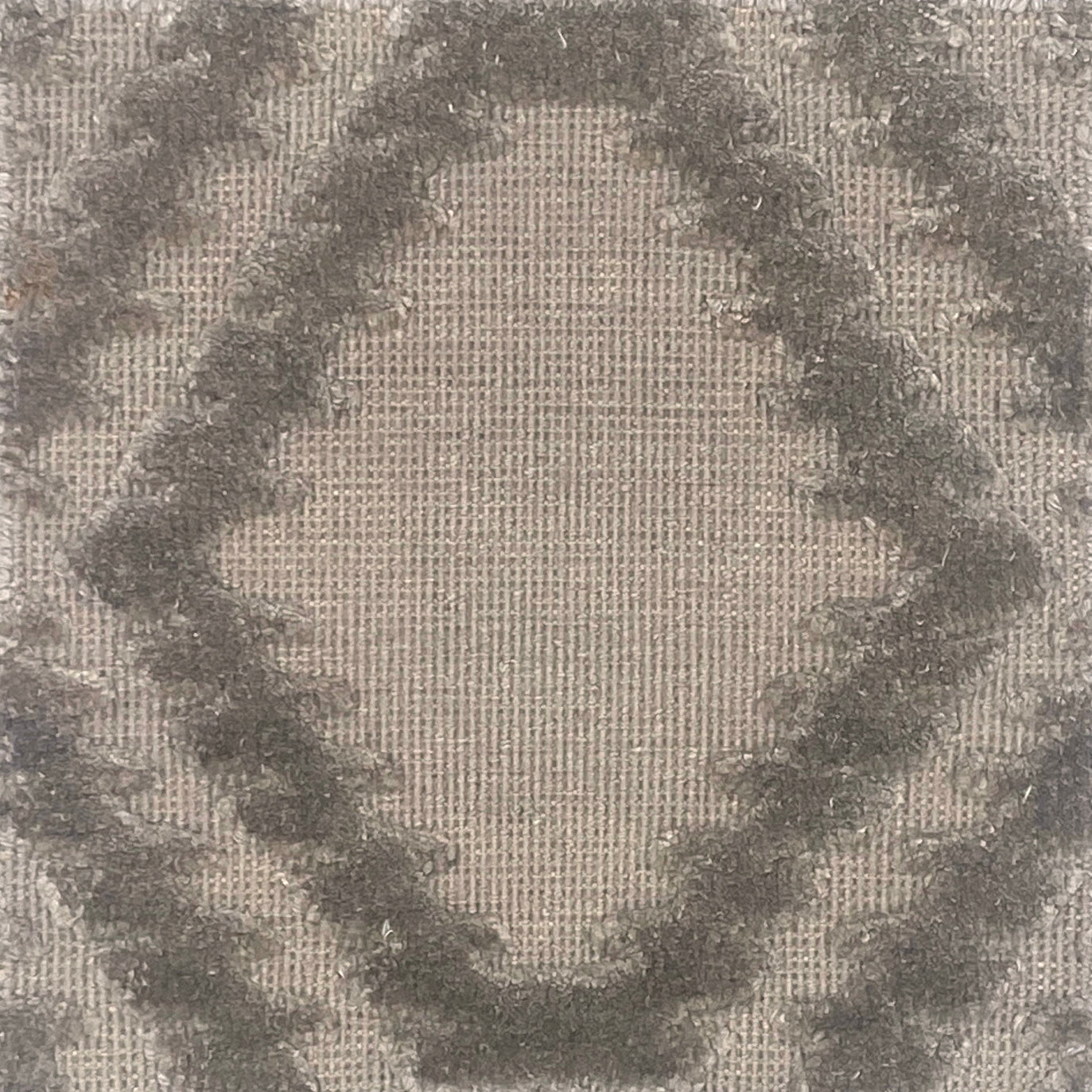 Handknotted rug with raised geometric pattern in grey. 