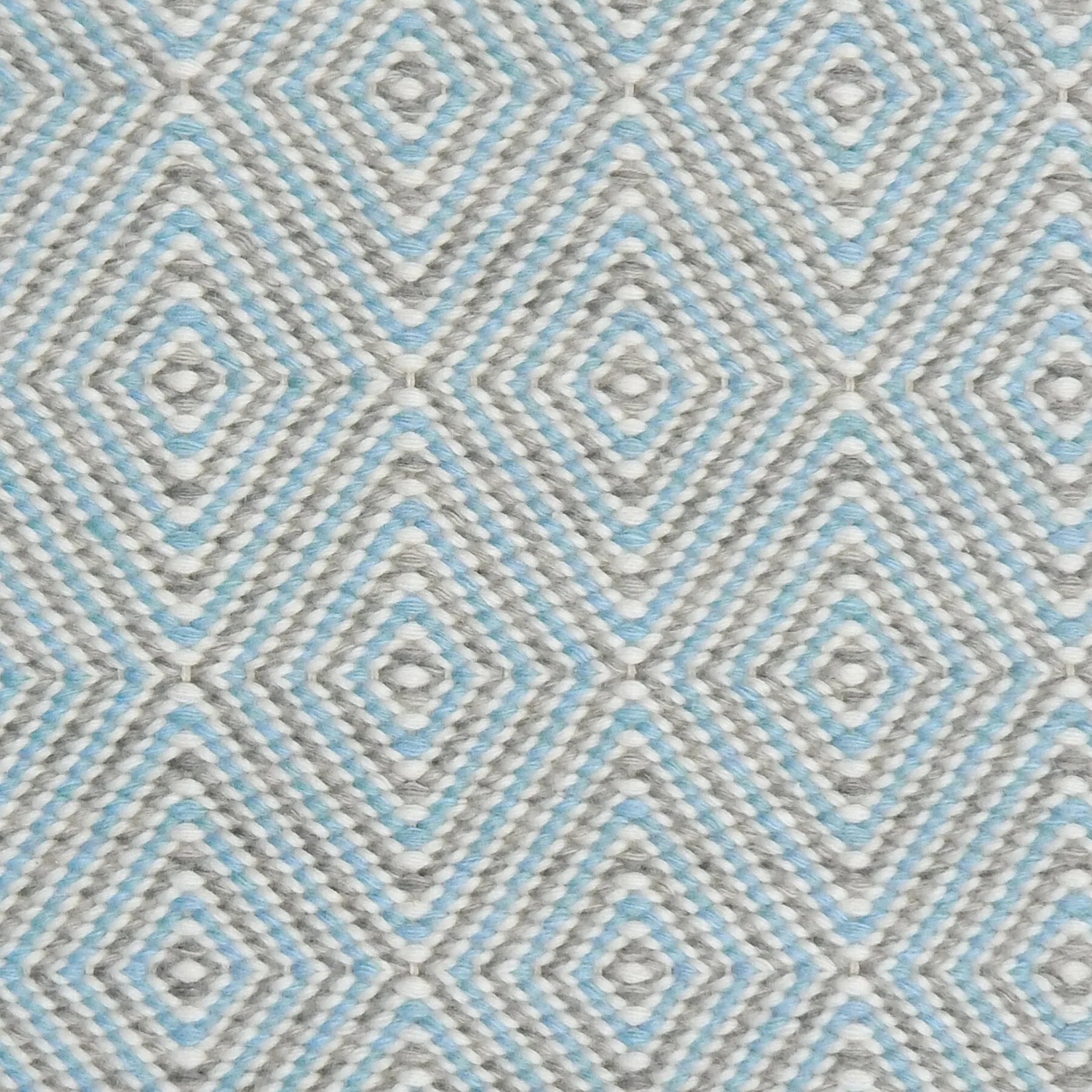 Handwoven rug in a geometric diamond pattern in light blue, grey and white. 