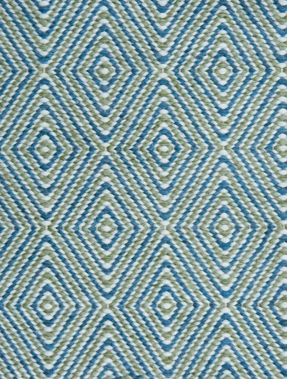 Handwoven rug in a geometric diamond pattern in blue, green and white. 