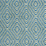Handwoven rug in a geometric diamond pattern in blue, green and white. 