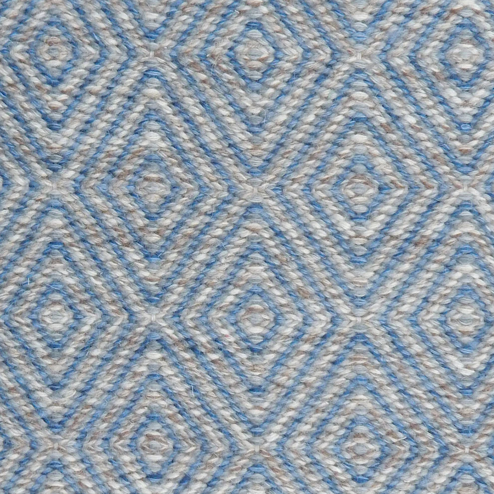 Handwoven rug in a geometric diamond pattern in blue and grey. 