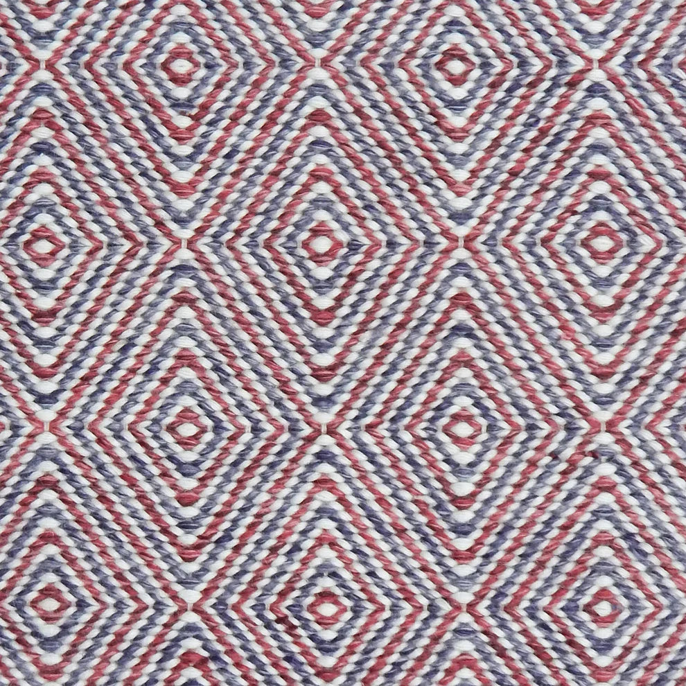 Handwoven rug in a geometric diamond pattern in red and purple. 