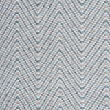 Handwoven rug in a herringbone pattern in pink, grey and white. 