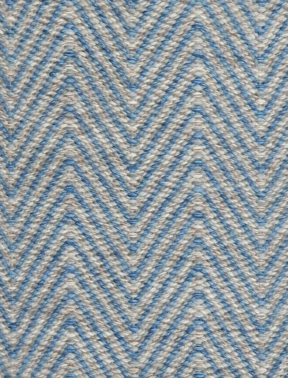 Handwoven rug in a herringbone pattern in blue and grey. 