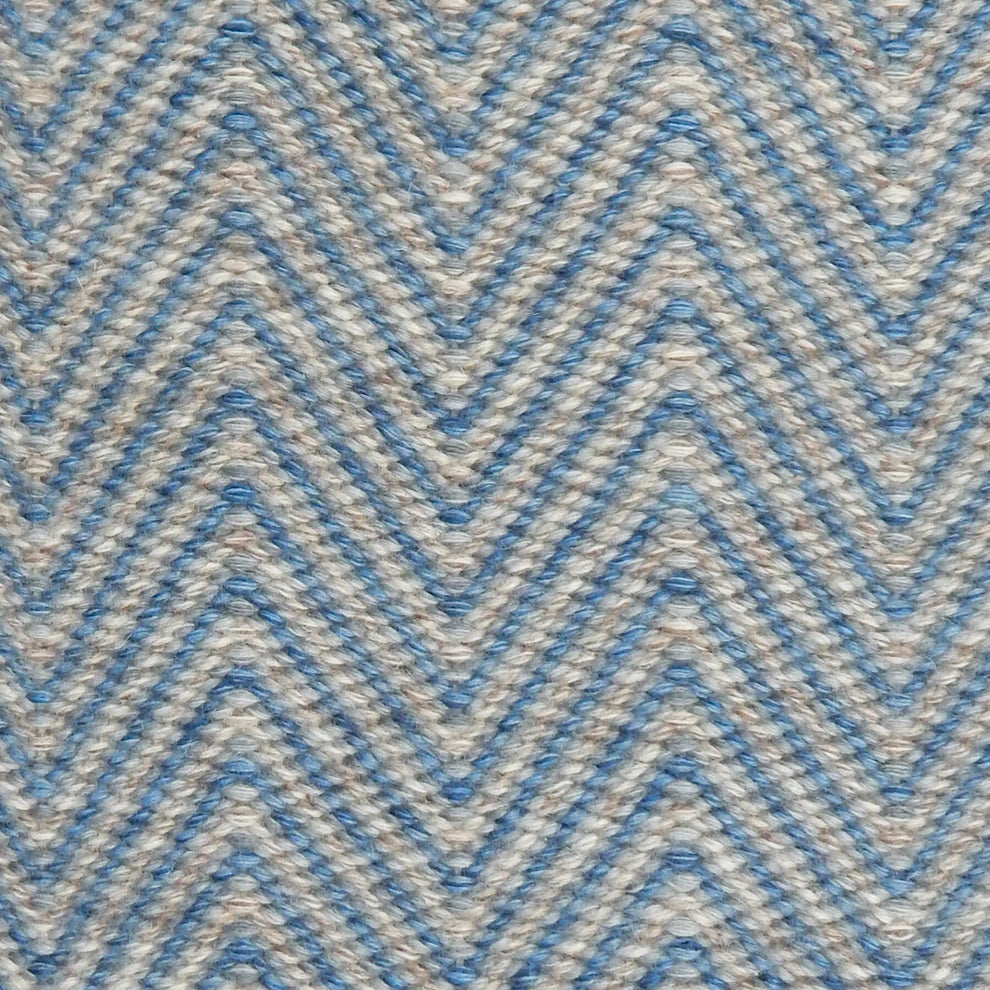 Handwoven rug in a herringbone pattern in blue and grey. 