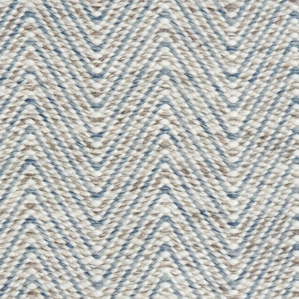 Handwoven rug in a herringbone pattern in blue, grey and white. 