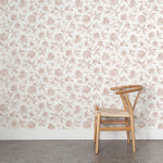 Wooden chair against a clay and white floral wallpapered wall