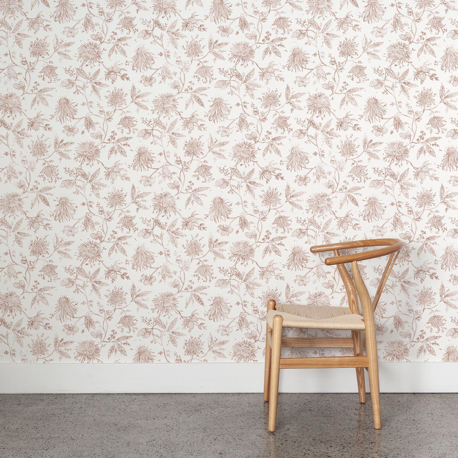Wooden chair against a clay and white floral wallpapered wall