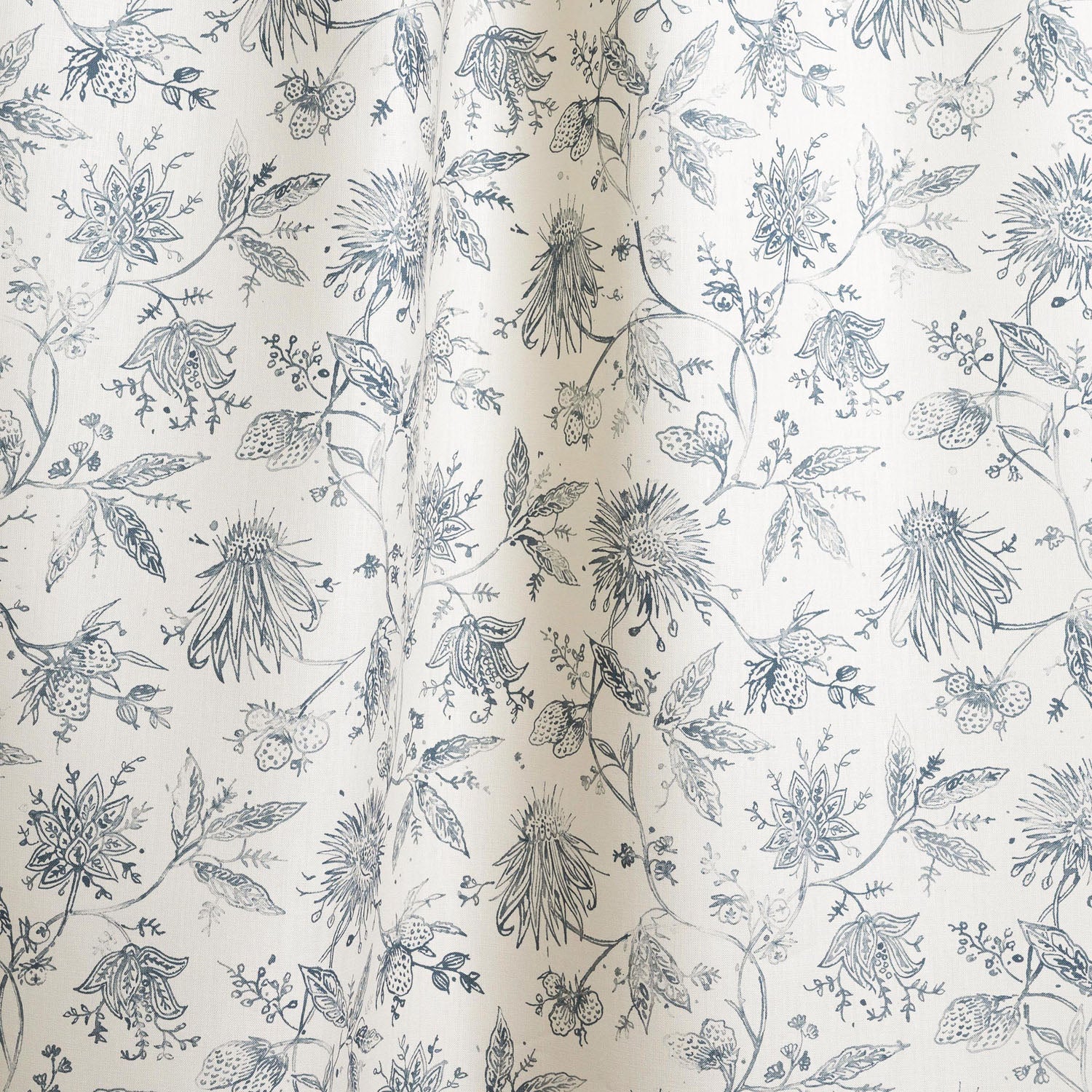 Draped fabric with watercolor floral pattern with ink blue leaves and flowers on a cream background