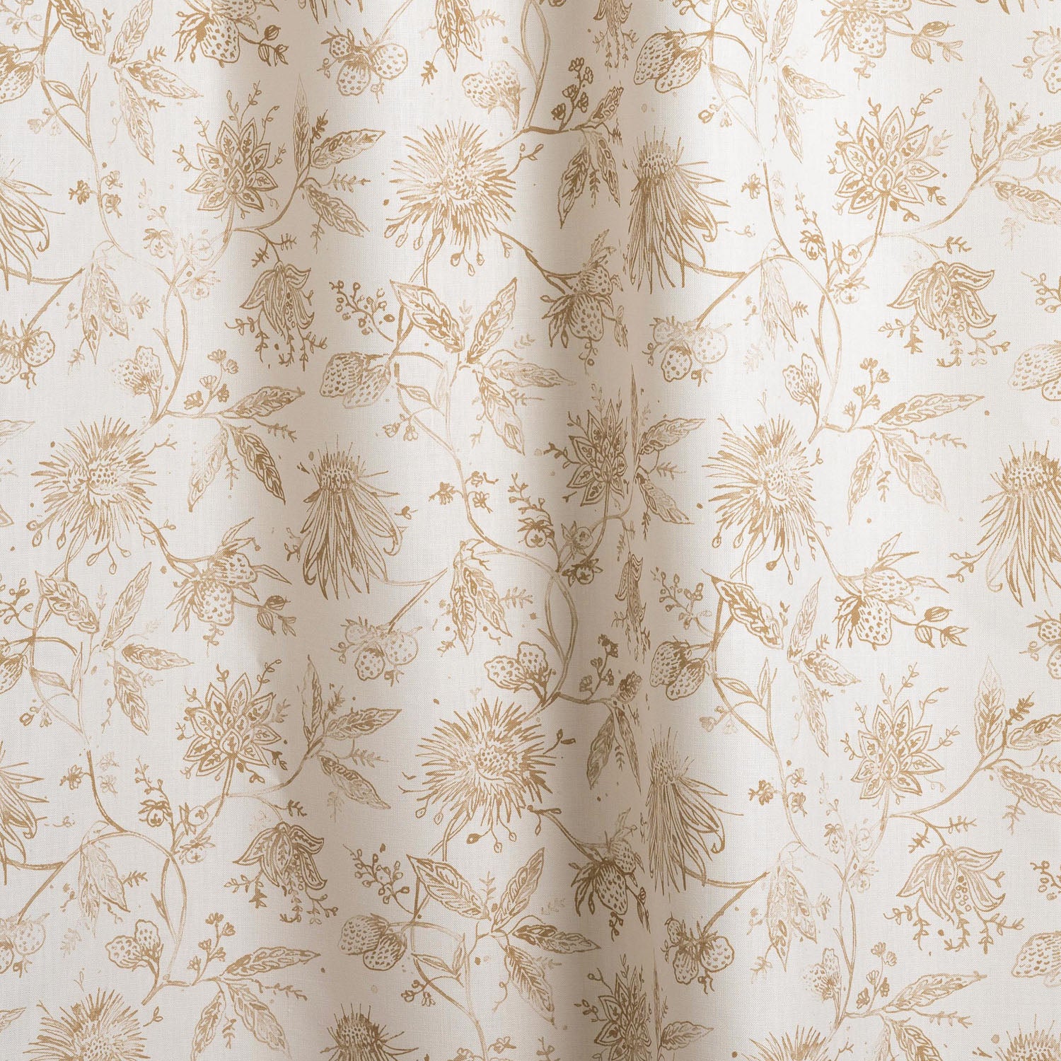 Draped fabric with watercolor floral pattern with tan leaves and flowers on a cream background