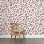 Wooden chair against a purple and white floral wallpapered wall