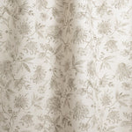 Draped fabric in watercolor floral pattern with grey-green leaves and flowers on a cream background
