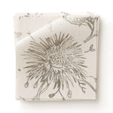Fabric swatch in watercolor floral pattern with grey-green leaves and flowers on a cream background