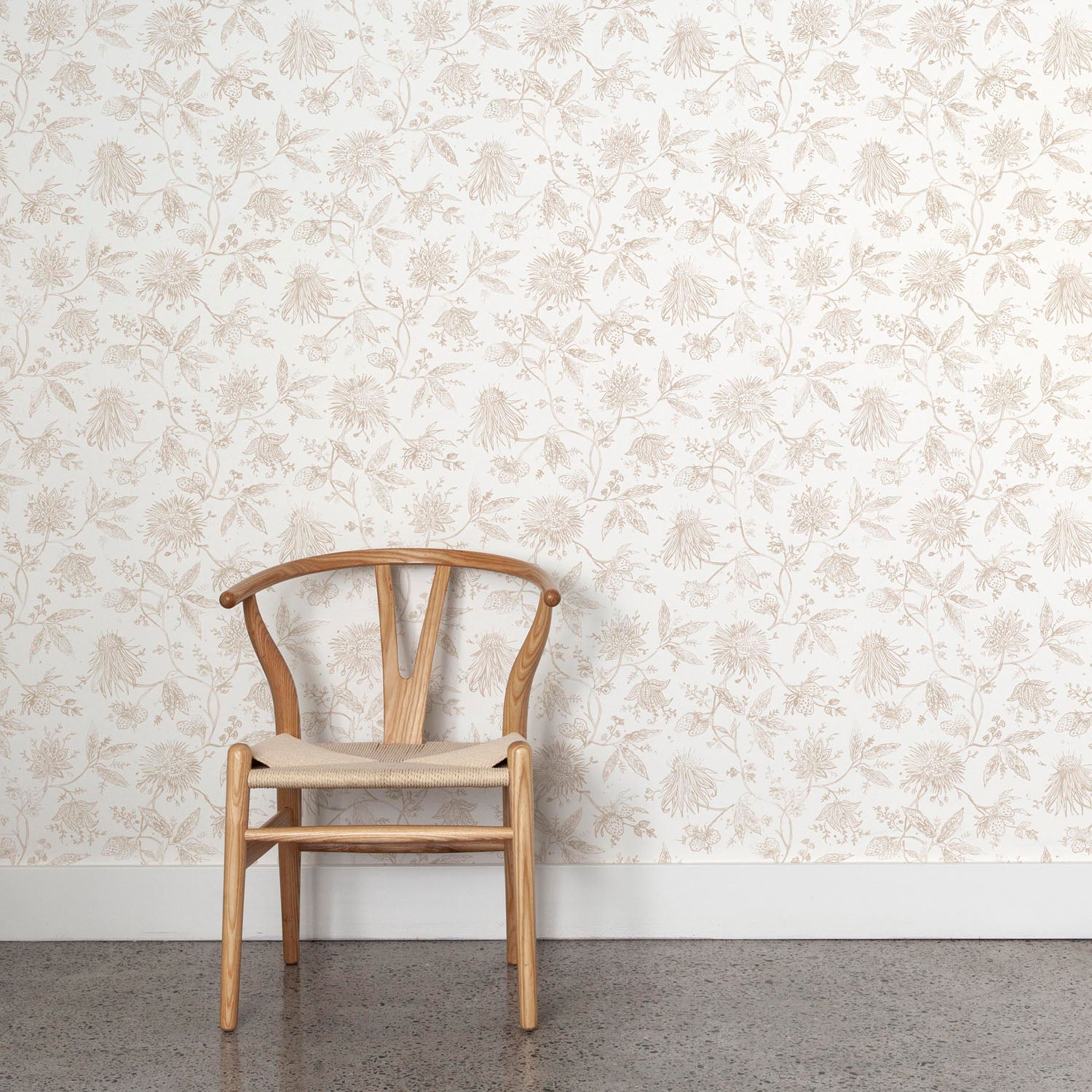 Wooden chair against a tan and white floral wallpapered wall