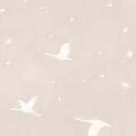 Detail of wallpaper in a repeating print of birds and stars in white on a soft beige watercolor field.