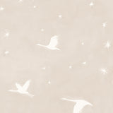 Detail of wallpaper in a repeating print of birds and stars in white on a soft beige watercolor field.