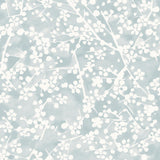 Detail of wallpaper in a painterly branch print in white on a light blue watercolor field.