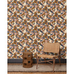 A wooden chair and end table in front of a wall papered in a painterly geometric pattern in shades of mauve, brown, cream and navy.
