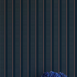 Navy blue wallpaper with thin white stripes and a vase of blue flowers on a white surface.
