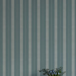Striped wallpaper with a vase of flowers in the foreground
