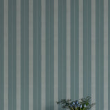 Striped wallpaper with a vase of flowers in the foreground