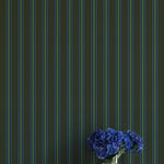Striped wallpaper with a vase of blue flowers on a white surface