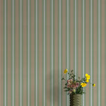 Striped wallpaper with a vase of flowers in the foreground