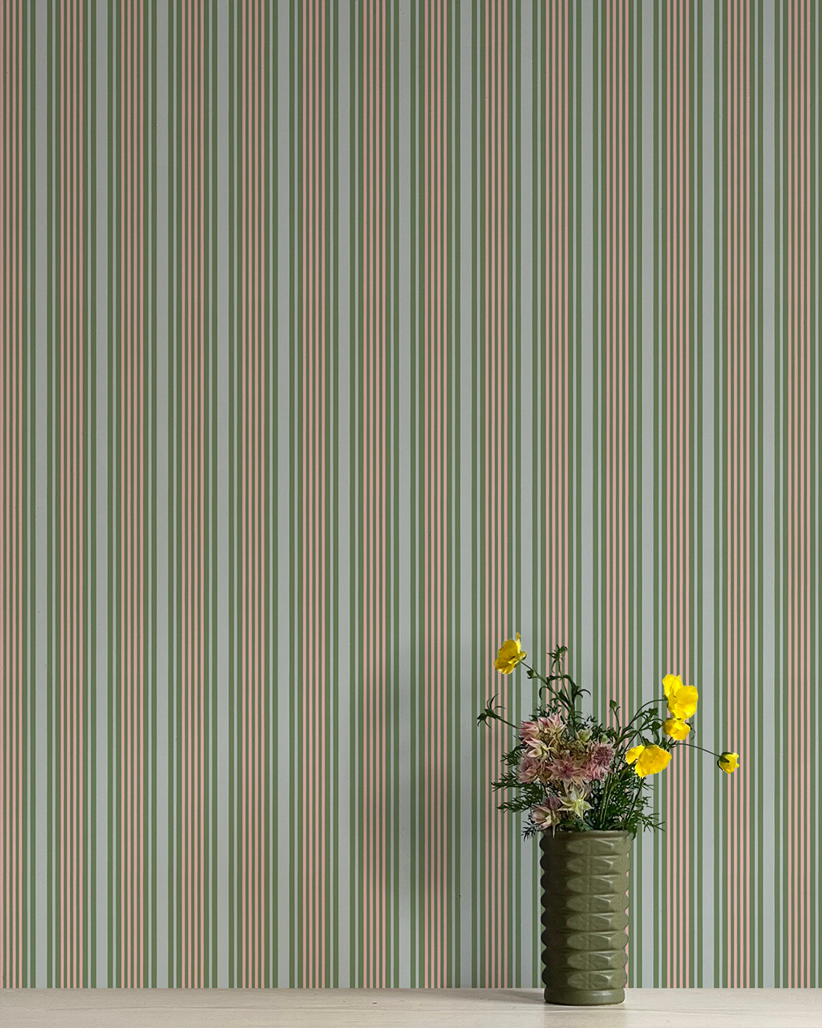 Striped wallpaper with a vase of flowers in the foreground