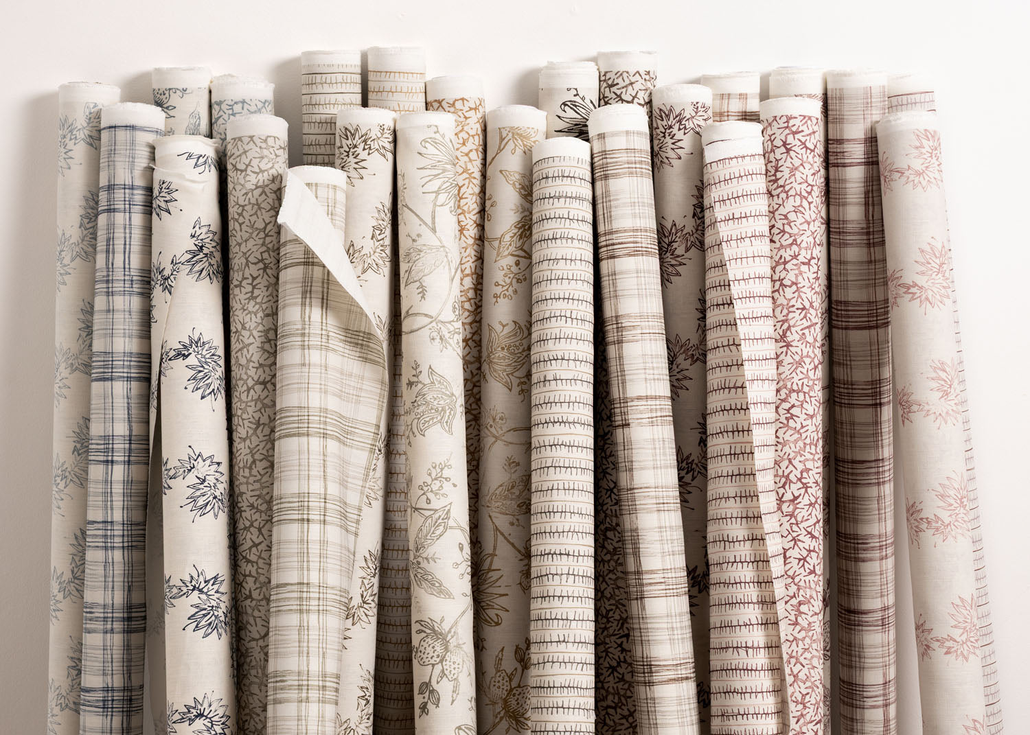 Collection of fabric rolls with various patterns on a white background