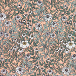 Detail of fabric in a dense floral print in white, tan and green on a light pink field.