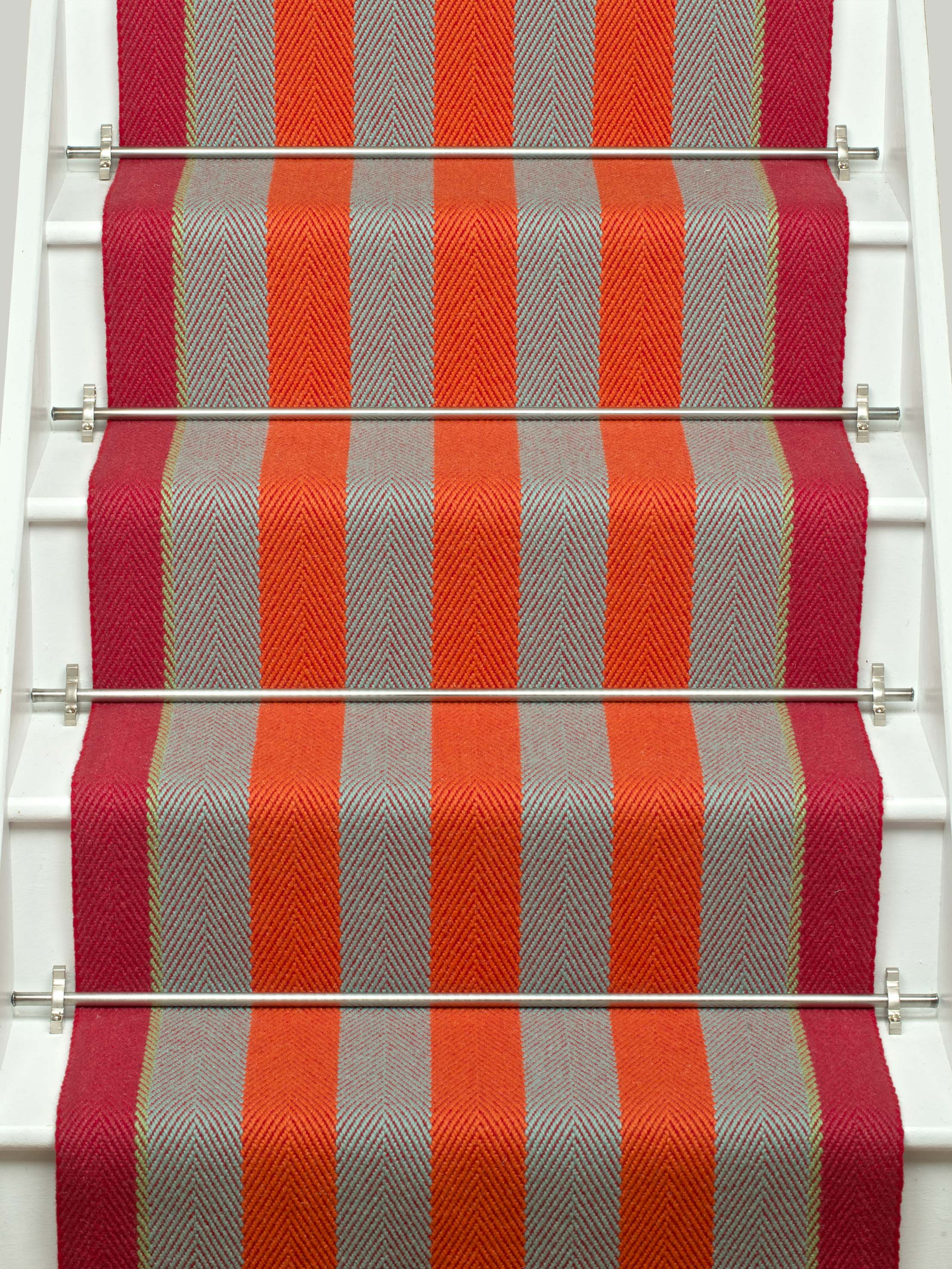 Striped flatweave runner in orange and red and white staircase
