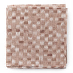 A stack of fabric swatches in a painterly checked pattern in shades of pink.